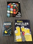 1970 80 Vintage Game Books Merlin Puzzler, Rubik Cube Soln Master Pacman. Fixed Price $30.00.